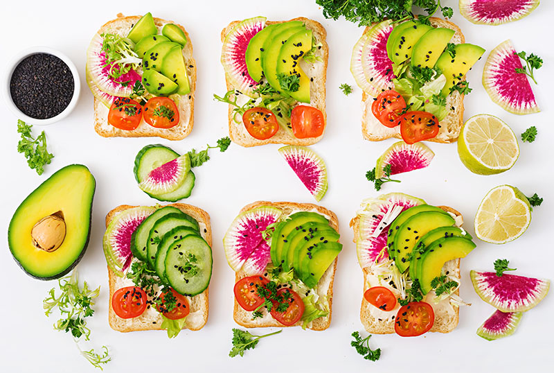 Vegan sandwiches with avocado, watermelon radish and tomatoes image