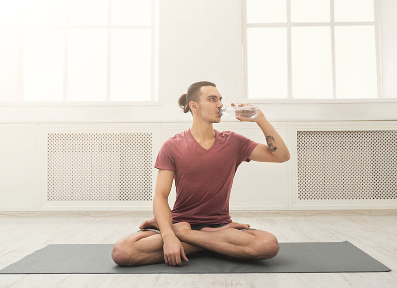 man drinking water during yoga class image