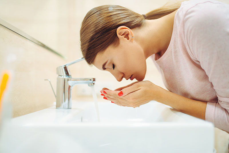 Woman washes her face image